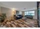 Living room with wood-look floors, comfy seating, and a large window at 5404 Flora Ave, Holiday, FL 34690