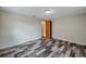 Well-lit bedroom with wood-look floors and access to a hallway at 5404 Flora Ave, Holiday, FL 34690