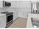 Modern kitchen with stainless steel appliances and white cabinets at 6999 Burnsville St, Englewood, FL 34224