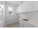 Laundry room with white cabinets, quartz countertop, and a utility sink at 6999 Burnsville St, Englewood, FL 34224