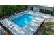 A fenced community pool surrounded by lounge chairs on a concrete patio, perfect for relaxation and socializing at 12703 Tall Pine Dr, Tampa, FL 33625