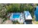 Aerial view of a tranquil community pool surrounded by nature and a serene lake at 12703 Tall Pine Dr, Tampa, FL 33625