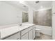 Bright bathroom with dual sinks, quartz countertop, and a shower-tub combo with gray tiling at 4265 Big Sky Dr, Spring Hill, FL 34604