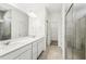 Bathroom featuring double sinks, modern vanity and tiled walk-in shower with glass door at 4265 Big Sky Dr, Spring Hill, FL 34604