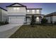 Charming two-story home boasts a modern color scheme, attached two-car garage, and landscaped front yard at 4265 Big Sky Dr, Spring Hill, FL 34604