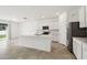 Bright, white kitchen features stainless steel appliances and a spacious island with breakfast bar at 4265 Big Sky Dr, Spring Hill, FL 34604