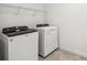The laundry room has a side-by-side washer and dryer with white appliances and white wire shelving at 4265 Big Sky Dr, Spring Hill, FL 34604