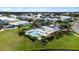 Aerial view of a community pool with a cabana, surrounded by palm trees, and well-maintained landscaping at 6404 Key Island Ave, Apollo Beach, FL 33572
