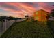 Waterfront backyard view with a well-manicured lawn and beautiful sunset in the background at 6404 Key Island Ave, Apollo Beach, FL 33572
