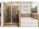 Modern bathroom featuring a tiled shower, garden tub, and natural light from the shuttered window at 6404 Key Island Ave, Apollo Beach, FL 33572