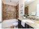 Well-lit bathroom with tile, tub, granite countertop, vanity, and ceramic tile flooring at 6404 Key Island Ave, Apollo Beach, FL 33572
