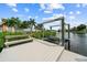 Exterior view of a private boat lift and wooden dock with a bench overlooking the calm water at 6404 Key Island Ave, Apollo Beach, FL 33572
