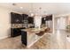 Spacious kitchen featuring an island with seating, sleek appliances, granite countertops and dark wood cabinetry at 6404 Key Island Ave, Apollo Beach, FL 33572