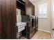 Functional laundry room with dark wood cabinets, sink, and modern washer and dryer at 6404 Key Island Ave, Apollo Beach, FL 33572