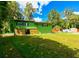 Green house exterior with lush lawn and trees at 4617 John Moore Rd, Brandon, FL 33511