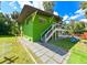 Green house exterior with a deck, walkway, and grassy yard at 4617 John Moore Rd, Brandon, FL 33511