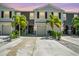 Two-story townhome with gray siding, two-car garage, and palm trees at dusk at 6633 Serenity Fall Ln, Sarasota, FL 34240