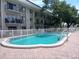 Community pool with brick deck and surrounding landscaping at 4606 W Gray St # 110, Tampa, FL 33609