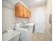 Laundry room with washer, dryer, cabinets and utility sink at 1704 Cresswell Manor Ct, Dover, FL 33527
