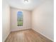 Empty bedroom featuring wood-look floors and an arched window at 1704 Cresswell Manor Ct, Dover, FL 33527