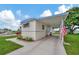Mobile home with covered carport and American flag at 122 E Saint Annes Cir, Apollo Beach, FL 33572