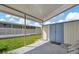 Covered patio area with storage shed and grassy yard at 122 E Saint Annes Cir, Apollo Beach, FL 33572