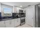 Modern kitchen with white cabinets, black countertops, and stainless steel appliances at 1819 Shore S Dr # 318, South Pasadena, FL 33707