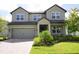 Two story home with gray siding and a three-car garage at 5776 Newberry Pines Ave, Wesley Chapel, FL 33545