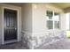 Front entry with dark wood door and stone accents at 5776 Newberry Pines Ave, Wesley Chapel, FL 33545
