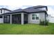 Gray house exterior with a screened porch and lush green lawn at 5776 Newberry Pines Ave, Wesley Chapel, FL 33545