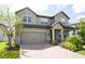 Two story home with gray siding and a three-car garage at 5776 Newberry Pines Ave, Wesley Chapel, FL 33545