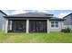 Gray house exterior with screened porch and well-manicured lawn at 5776 Newberry Pines Ave, Wesley Chapel, FL 33545