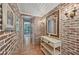 Charming hallway with exposed brick walls and a decorative console table at 608 Armada S Rd, Venice, FL 34285