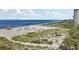Beach volleyball court and ocean view; people relaxing on the beach at 608 Armada S Rd, Venice, FL 34285