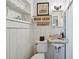 Charming bathroom with rustic sink, wood-paneled walls, and a toilet at 608 Armada S Rd, Venice, FL 34285
