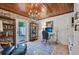 Home office with brick accent wall, built in shelving, and hardwood floors at 608 Armada S Rd, Venice, FL 34285