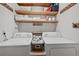 Bright laundry room with washer, dryer, and ample shelving at 608 Armada S Rd, Venice, FL 34285
