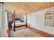 Bright bedroom with wood floors, brick accent wall, and a four-poster bed at 608 Armada S Rd, Venice, FL 34285