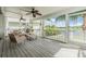 Relaxing screened porch overlooking a lake, featuring wicker furniture and ceiling fans at 2118 Harbour Watch Dr, Tarpon Springs, FL 34689
