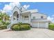 Two-story home with white siding, gray roof, and a three-car garage at 2118 Harbour Watch Dr, Tarpon Springs, FL 34689