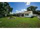 House exterior showcasing a large backyard and screened patio at 8807 Shenandoah Ln, Hudson, FL 34667