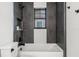 Modern bathroom with gray tile, a white tub, and a window for natural light at 321 W Hanlon St, Tampa, FL 33604
