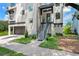 Modern home featuring a two-car garage, landscaped front yard, and a stylish entryway with stairs at 321 W Hanlon St, Tampa, FL 33604