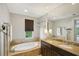 Spa-like bathroom featuring a large soaking tub, double vanity, and window at 450 Knights Run Ave # 411, Tampa, FL 33602