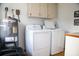 Laundry room with washer, dryer, and overhead cabinets at 2503 W Marquette Ave, Tampa, FL 33614