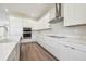 Elegant kitchen with white cabinetry, stainless steel appliances, quartz countertops, and hardwood flooring at 2206 N Boulevard, Tampa, FL 33602
