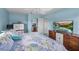 Bright bedroom featuring a cozy bed, dresser with a TV, and serene blue walls for a peaceful retreat at 4031 Eagle Nest Dr, Hernando Beach, FL 34607