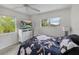 Inviting bedroom featuring large windows, hardwood floors, and a TV for ultimate relaxation and entertainment at 4031 Eagle Nest Dr, Hernando Beach, FL 34607