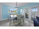 Cozy dining area with blue paneled walls and a door leading to an outdoor patio with scenic views at 4031 Eagle Nest Dr, Hernando Beach, FL 34607