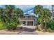 Elevated coastal home with palm trees, offering a unique waterfront setting at 4031 Eagle Nest Dr, Hernando Beach, FL 34607